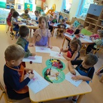 Dzieci przy stolikach kolorują obrazek