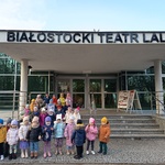Dzieci stoją przez budynkiem teatru