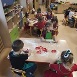 Dzieci siedzą i dekorują pierniczki
