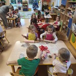 Dzieci siedzą i dekorują pierniczki