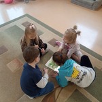 grupa dzieci siedzi na dywanie i wykonuje zadanie
