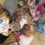 grupa dzieci siedzi na dywanie i wykonuje zadanie