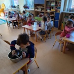 Dzieci sadzą rośliny do małych doniczek