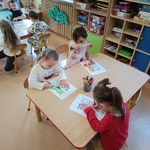 Dzieci pracują przy stoliku z kartą zadań