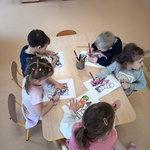 Dzieci pracują przy stoliku z kartą zadań