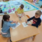 Dzieci pracują przy stoliku z kartą zadań