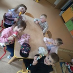 Dzieci siedzą przy stoliku, jedzą lody