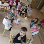 Dzieci siedzą przy stoliku, jedzą lody