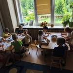 Dzieci pracują na zajęciach przy stolikach