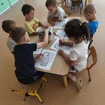 Dzieci pracują na zajęciach przy stolikach